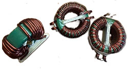 Three Coiltron green-core toroidal common-mode chokes with copper wire windings and integrated white mounting bases for PCB assembly.