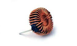 Close-up of a Coiltron toroidal inductor featuring dense copper wire winding and a visible lead for through-hole PCB mounting.